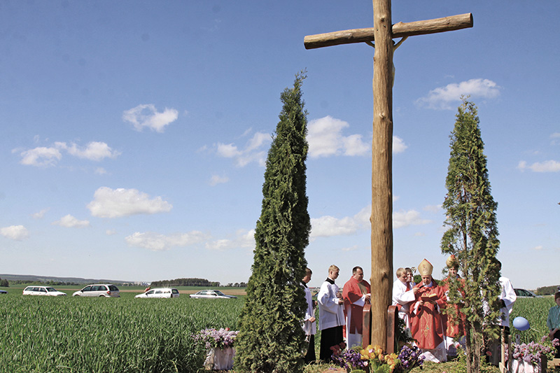 Biskup Aleksander Kaszkiewicz poświęca krzyż i ziemię pod budowę kościoła